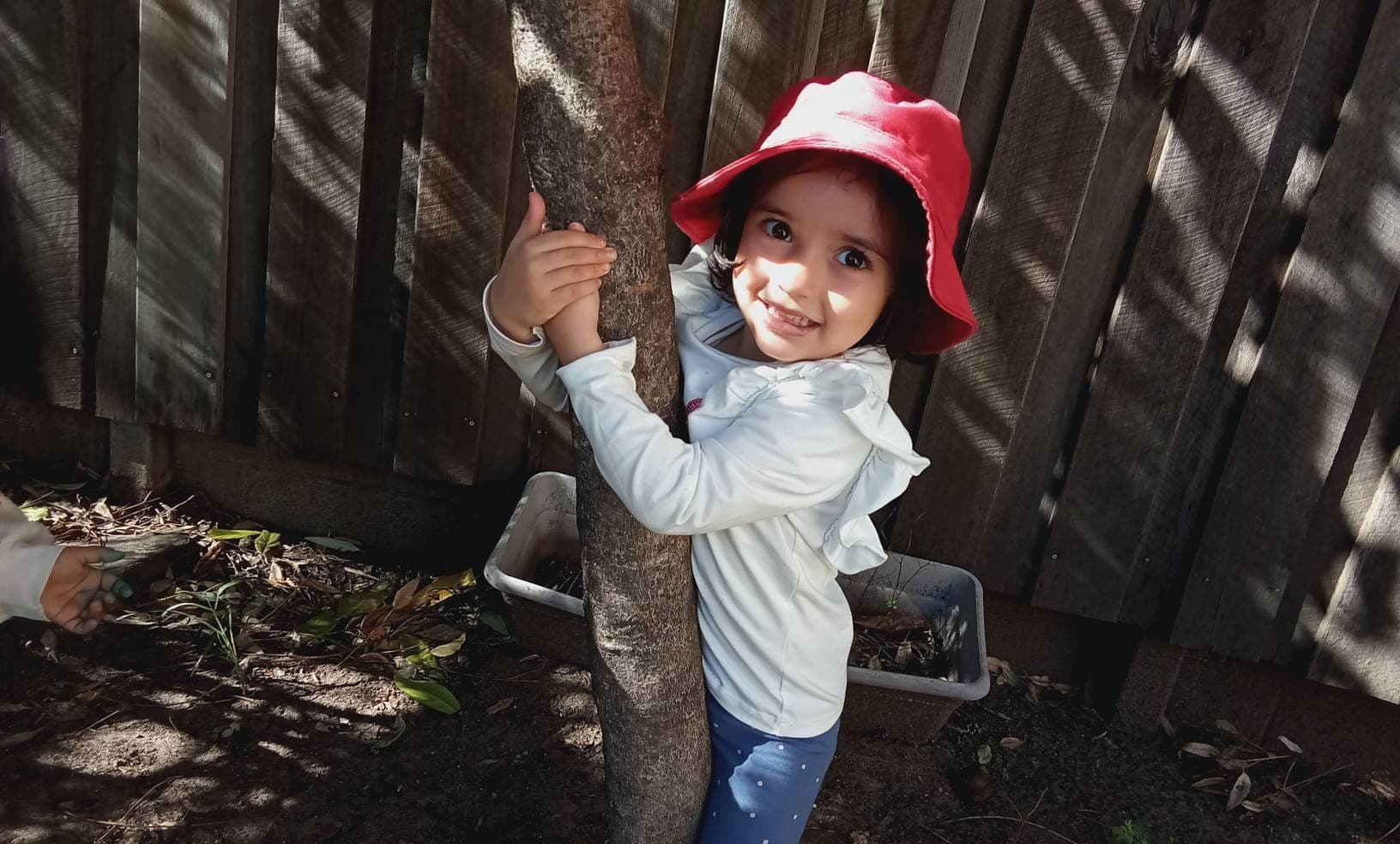 A child exploring the garden in the nature play space at The Munro Centre, St Lucia